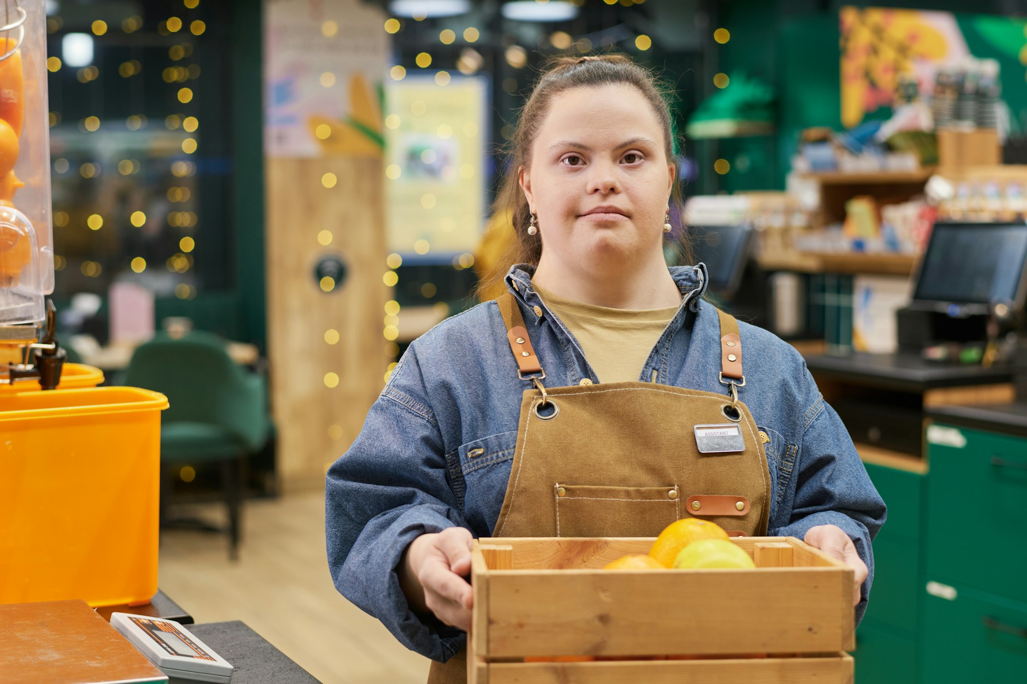 Girl with Disability Working in Supermarket Holding Box with Fresh Fruits