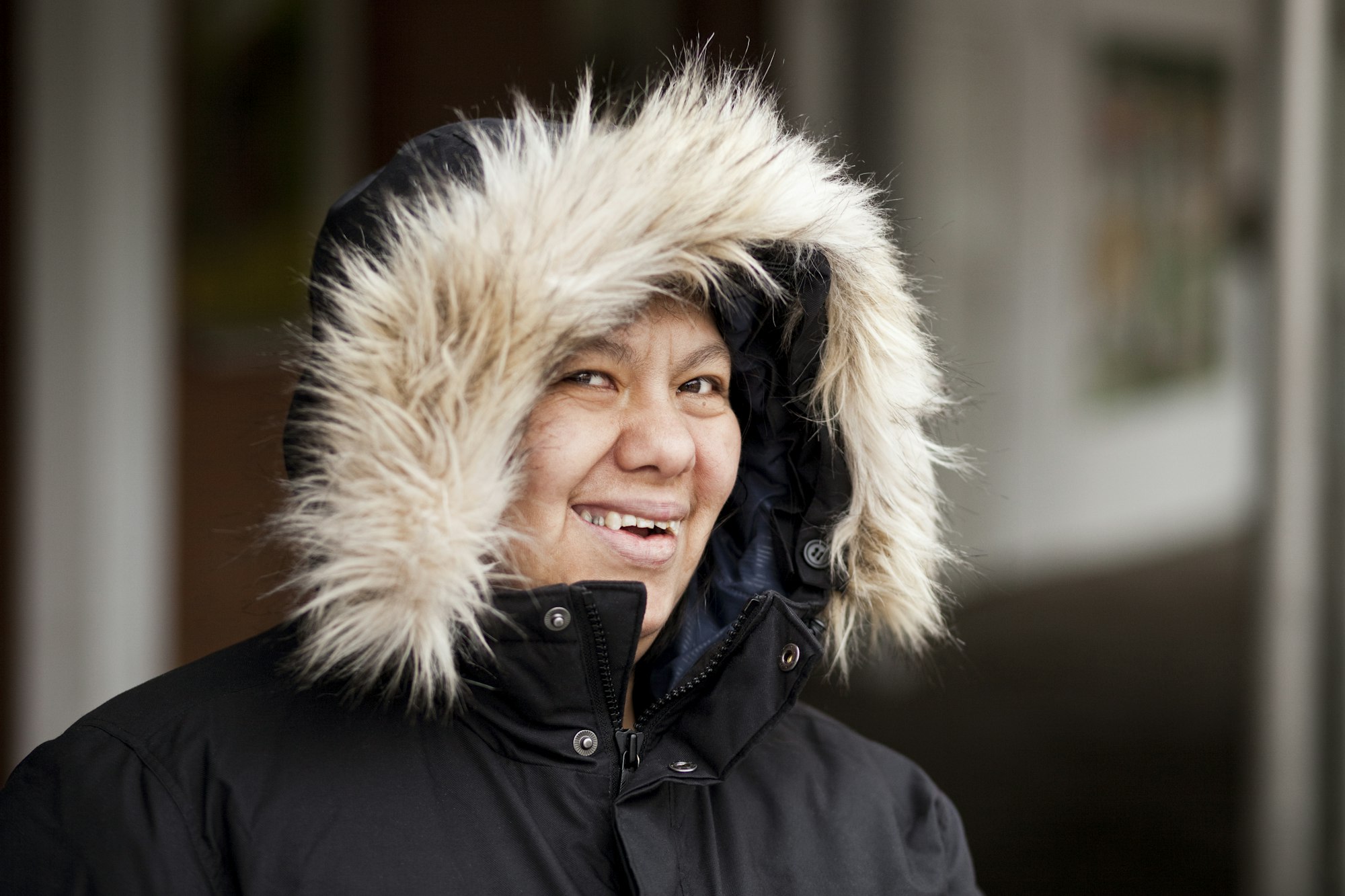 Portrait of smiling mature woman with down syndrome wearing fake fur